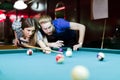 Young handsome man and woman flirting while playing snooker
