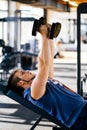 Young handsome man working out with dumbbells in a fitness gym Royalty Free Stock Photo