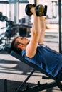 Young handsome man working out with dumbbells in a fitness gym Royalty Free Stock Photo