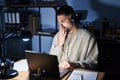 Young handsome man working using computer laptop at night bored yawning tired covering mouth with hand Royalty Free Stock Photo