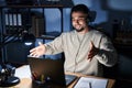 Young handsome man working using computer laptop at night looking at the camera smiling with open arms for hug Royalty Free Stock Photo