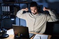 Young handsome man working using computer laptop at night showing arms muscles smiling proud Royalty Free Stock Photo