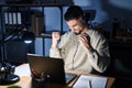 Young handsome man working using computer laptop at night very happy and excited doing winner gesture with arms raised, smiling Royalty Free Stock Photo