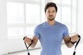 Young handsome man during workout with a resistance rubber bands in the gym. Royalty Free Stock Photo