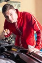 Young handsome mechanic checking the oil level in a car engine Royalty Free Stock Photo