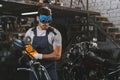 young handsome mechanic in goggles with circular saw in workshop Royalty Free Stock Photo