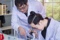 Young handsome medical student and research assistant with microscopes