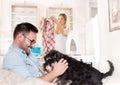 Man playing with dog and woman doing housework Royalty Free Stock Photo