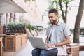 Young handsome men using laptop in a city. Smiling student man having coffee break. Modern lifestyle, connection, business concept Royalty Free Stock Photo