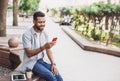 Young handsome men using smartphone in a city. Smiling student man texting on his mobile phone. Coffee break. Royalty Free Stock Photo