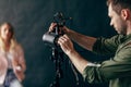 Young handsome man working with a professional studio strobe photo flash light. Royalty Free Stock Photo