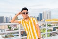 Young handsome multi ethnic man wearing sunglasses against view of the city Royalty Free Stock Photo