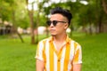 Young handsome multi ethnic man wearing sunglasses at the park outdoors Royalty Free Stock Photo