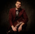 Young handsome old-fashioned man with briefcase posing on dark background. Royalty Free Stock Photo