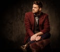 Young handsome old-fashioned man with briefcase posing on dark background. Royalty Free Stock Photo