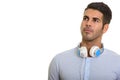 Young handsome Persian man thinking while wearing headphones aro