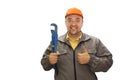 Young handsome plumber worker with adjustable wrench. Isolated over white background. Royalty Free Stock Photo