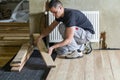 Young handsome professional carpenter installing natural wooden