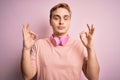 Young handsome redhead man listening to music using headphones over pink background relax and smiling with eyes closed doing Royalty Free Stock Photo