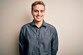 Young handsome redhead man wearing casual shirt standing over isolated white background with a happy and cool smile on face Royalty Free Stock Photo