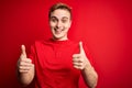 Young handsome redhead man wearing casual t-shirt over isolated red background success sign doing positive gesture with hand, Royalty Free Stock Photo