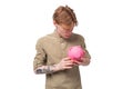 young handsome redhead student man holding piggy bank with savings Royalty Free Stock Photo