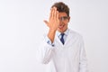 Young handsome sciencist man wearing glasses and coat over isolated white background covering one eye with hand, confident smile Royalty Free Stock Photo