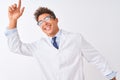 Young handsome sciencist man wearing glasses and coat over isolated white background Dancing happy and cheerful, smiling moving Royalty Free Stock Photo