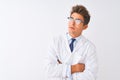 Young handsome sciencist man wearing glasses and coat over isolated white background looking to the side with arms crossed Royalty Free Stock Photo