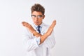 Young handsome sciencist man wearing glasses and coat over isolated white background Rejection expression crossing arms doing Royalty Free Stock Photo