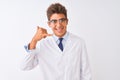 Young handsome sciencist man wearing glasses and coat over isolated white background smiling doing phone gesture with hand and Royalty Free Stock Photo