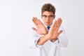 Young handsome sciencist man wearing glasses and coat over  white background Rejection expression crossing arms and palms Royalty Free Stock Photo