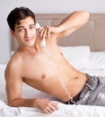 Young handsome shirtless guy showing nude torso sexy on bed at h Royalty Free Stock Photo
