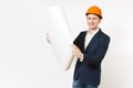 Young handsome smiling businessman in dark suit, protective construction orange helmet unrolling blueprint plan isolated Royalty Free Stock Photo