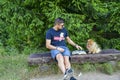 Young handsome smiling man  reading outdoor with a dog Royalty Free Stock Photo