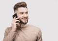 Young handsome smiling man talking on mobile phone. Student men using smartphone. Isolated closeup studio portrait, gray backgroun Royalty Free Stock Photo