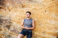 Young handsome sportsman getting ready to climb a cliff