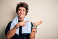 Young handsome sportsman wearing towel standing over isolated white background amazed and smiling to the camera while presenting Royalty Free Stock Photo