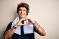 Young handsome sportsman wearing towel standing over isolated white background smiling in love showing heart symbol and shape with Royalty Free Stock Photo