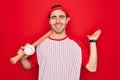 Young handsome sporty man with blue eyes playing baseball wearing cap holding bat and ball very happy and excited, winner Royalty Free Stock Photo