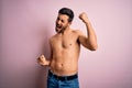Young handsome strong man with beard shirtless standing over isolated pink background Dancing happy and cheerful, smiling moving Royalty Free Stock Photo