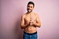 Young handsome strong man with beard shirtless standing over isolated pink background with hands together and crossed fingers Royalty Free Stock Photo