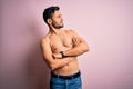 Young handsome strong man with beard shirtless standing over isolated pink background looking to the side with arms crossed Royalty Free Stock Photo