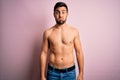 Young handsome strong man with beard shirtless standing over isolated pink background puffing cheeks with funny face Royalty Free Stock Photo