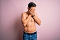 Young handsome strong man with beard shirtless standing over isolated pink background with sad expression covering face with hands Royalty Free Stock Photo