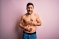 Young handsome strong man with beard shirtless standing over isolated pink background smiling and laughing hard out loud because