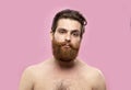 Young handsome strong man with beard shirtless standing over isolated pink background, looking at the camera. Royalty Free Stock Photo