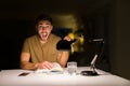 Young handsome student man studying at night at home screaming proud and celebrating victory and success very excited, cheering Royalty Free Stock Photo