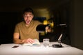 Young handsome student man studying at night at home very happy pointing with hand and finger Royalty Free Stock Photo