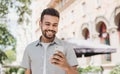 Young handsome student man using smartphone in a city. Cheerful smiling men holding mobile phone. Royalty Free Stock Photo